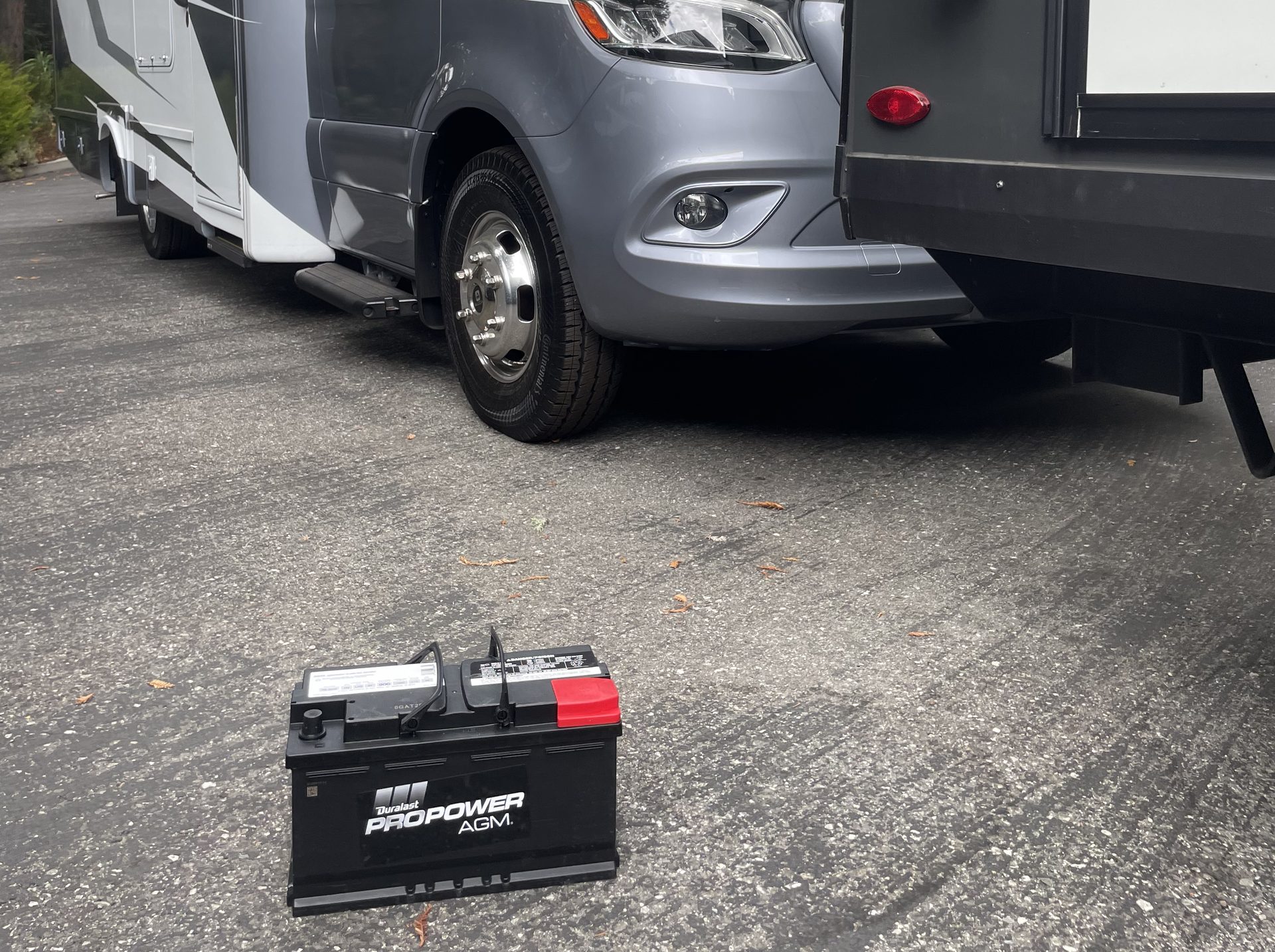 New AGM battery on the ground beside a motorhome during an Axl Roadside battery replacement